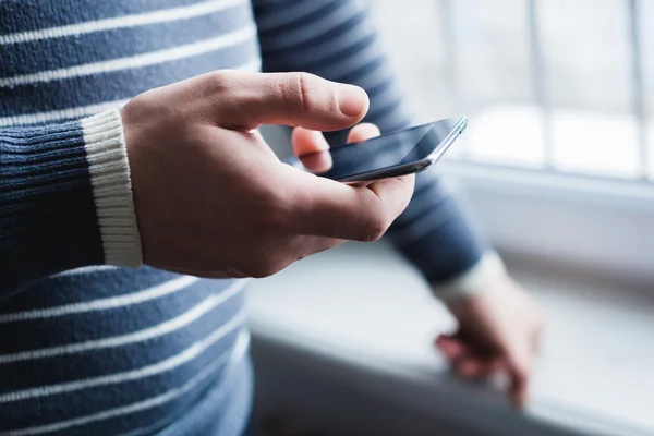 O homem está usando um smartphone. Telemóvel moderno na mão . — Fotografia de Stock