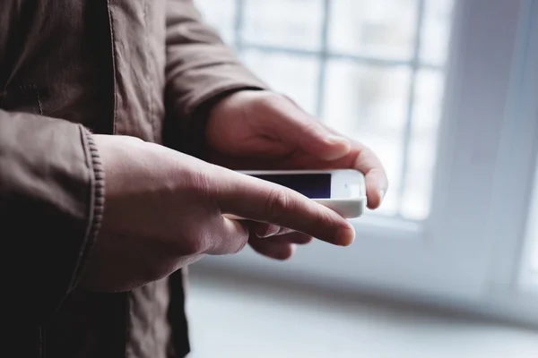 Han använder en smartphone. Modern mobiltelefon i handen. — Stockfoto