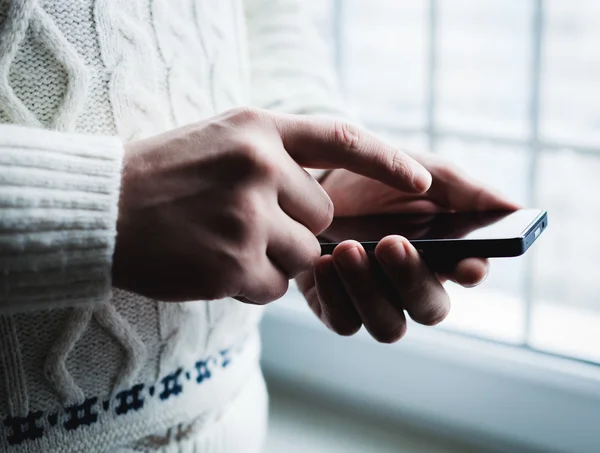 El hombre está usando un teléfono inteligente. Teléfono móvil moderno en la mano . — Foto de Stock