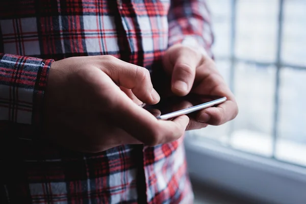 Han använder en smartphone. Modern mobiltelefon i handen. — Stockfoto