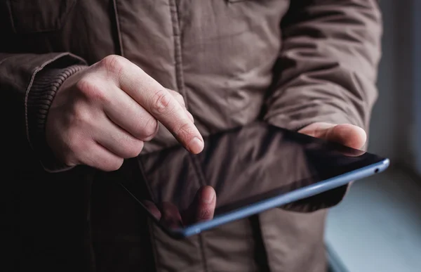 The man uses a tablet PC. Modern gadget in hand. — Stock Photo, Image