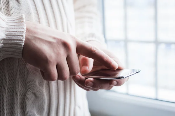 O homem está usando um smartphone. Telemóvel moderno na mão . — Fotografia de Stock