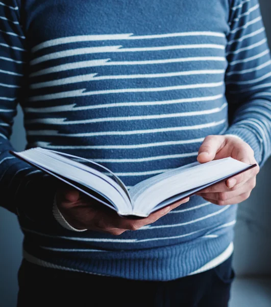 Un homme qui lit. Livre dans ses mains . — Photo