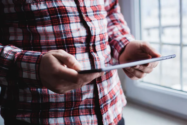 The man uses a tablet PC. Modern gadget in hand. — Stock Photo, Image