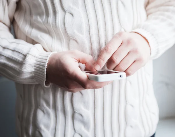 El hombre está usando un teléfono inteligente. Teléfono móvil moderno en la mano . — Foto de Stock