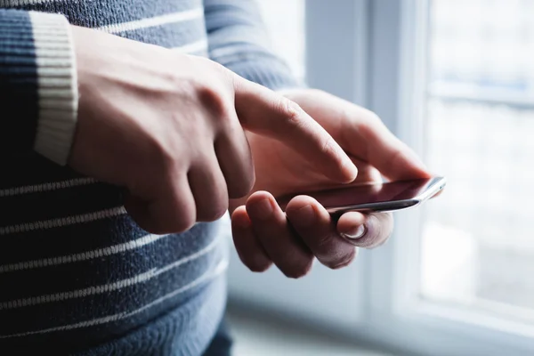 The man is using a smartphone. Modern mobile phone in hand. — Stock Photo, Image