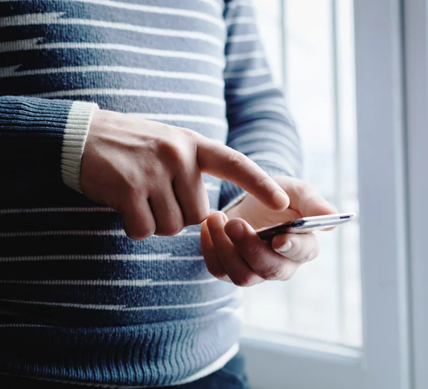 El hombre está usando un teléfono inteligente. Teléfono móvil moderno en la mano . —  Fotos de Stock