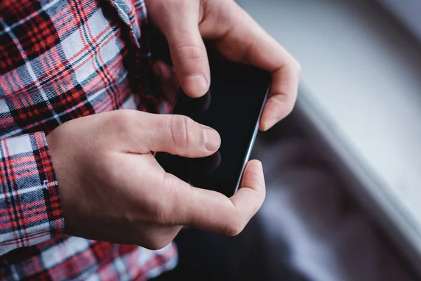 O homem está usando um smartphone. Telemóvel moderno na mão . — Fotografia de Stock