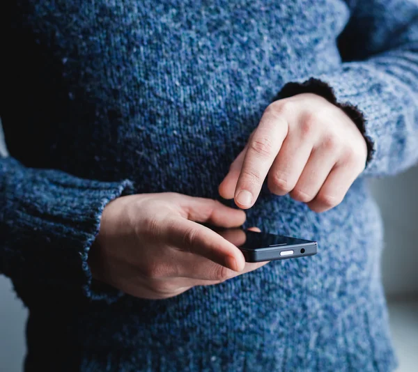 El hombre está usando un teléfono inteligente. Teléfono móvil moderno en la mano . — Foto de Stock