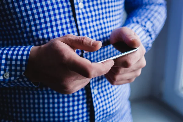 The man is using a smartphone. Modern mobile phone in hand. — Stock Photo, Image