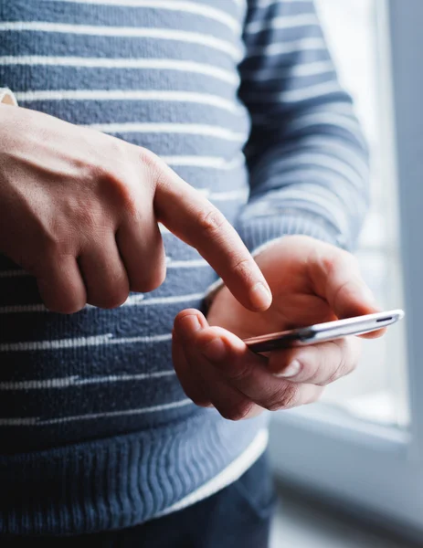 El hombre está usando un teléfono inteligente. Teléfono móvil moderno en la mano . —  Fotos de Stock