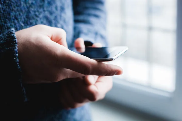 Han använder en smartphone. Modern mobiltelefon i handen. — Stockfoto