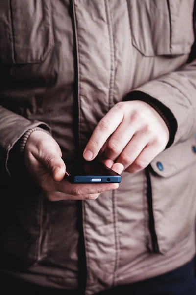 The man is using a smartphone. Modern mobile phone in hand. — Stock Photo, Image