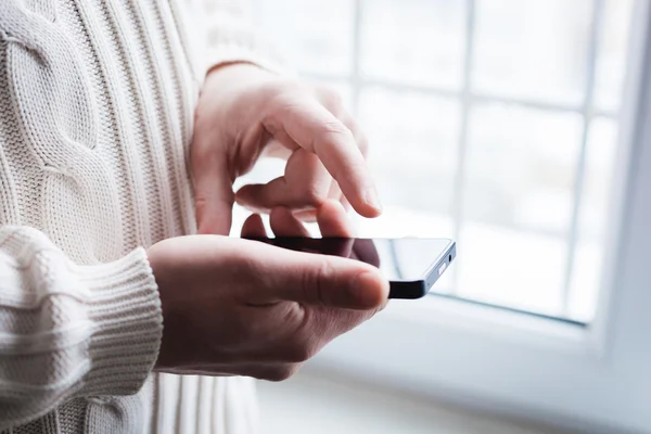 El hombre está usando un teléfono inteligente. Teléfono móvil moderno en la mano . — Foto de Stock