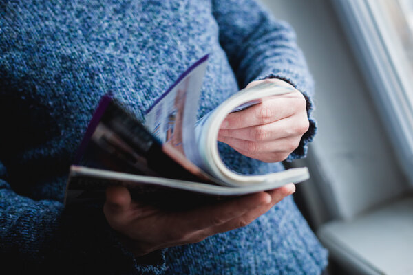 A man looks at a magazine. Press hands.