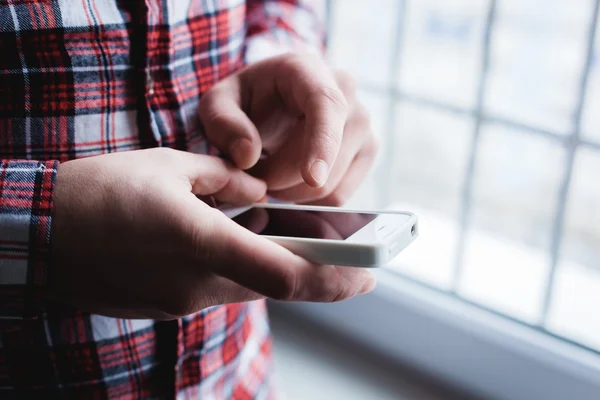 The man is using a smartphone. Modern mobile phone in hand. — Stock Photo, Image