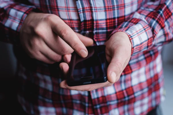 O homem está usando um smartphone. Telemóvel moderno na mão . — Fotografia de Stock