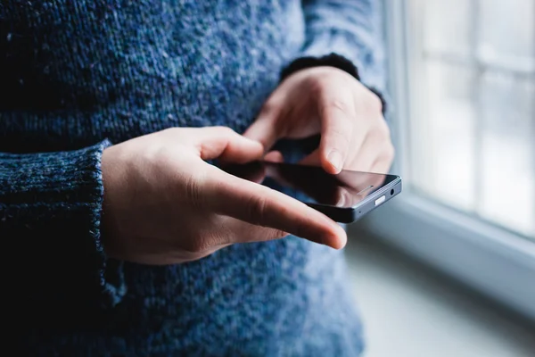 The man is using a smartphone. Modern mobile phone in hand. — Stock Photo, Image