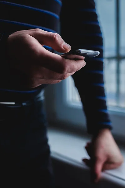 El hombre está usando un teléfono inteligente. Teléfono móvil moderno en la mano . — Foto de Stock