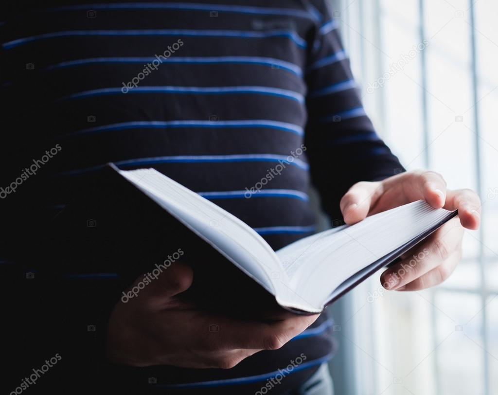 Man reading. Book in his hands.