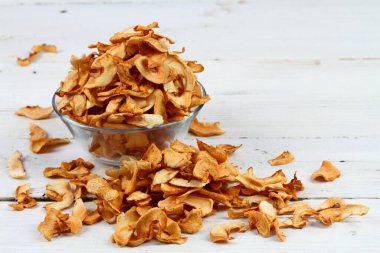 Bir kasede ev yapımı kurutulmuş elma. Beyaz ahşap masada kabuksuz kurutulmuş elma cipsi.. 