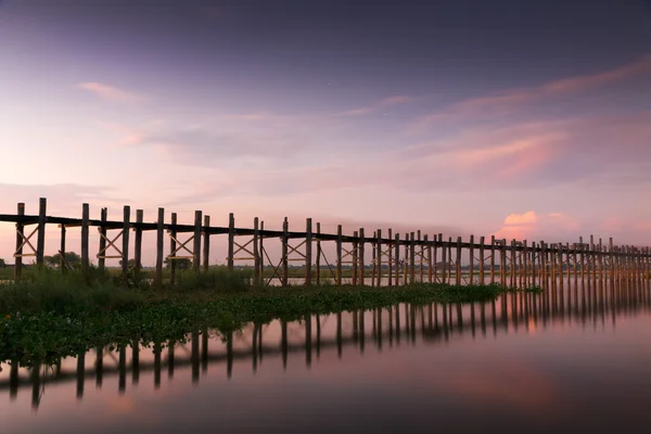 Trä teak u bein bridge glödande vid solnedgången Stockbild