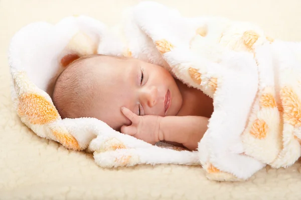 Baby lying and holding his head. — Stock Photo, Image