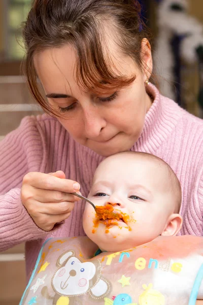 Maminka spoon-feeds dítě — Stock fotografie