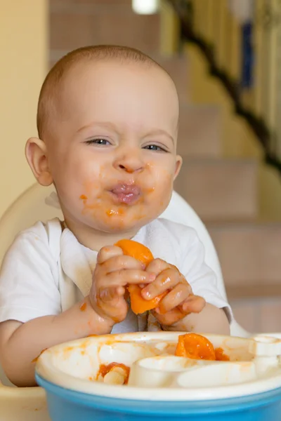 Любопытный мальчик ест абрикос — стоковое фото
