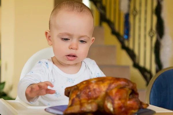 Bebé comiendo un gran pollo a la parrilla — Foto de Stock