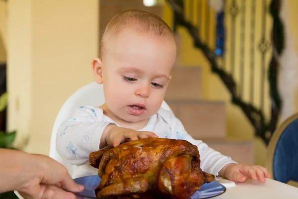 Bebé comiendo un gran pollo a la parrilla — Foto de Stock