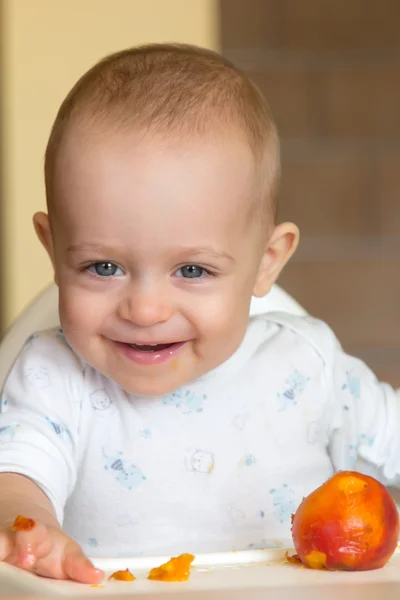 Bebé comiendo un melocotón — Foto de Stock