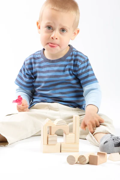 Pequeño chico lindo jugando con bloques de construcción. Aislado sobre blanco . — Foto de Stock