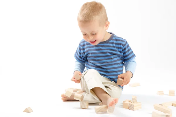 Маленький милый мальчик играет со строительными блоками. Изолированные на белом . — стоковое фото