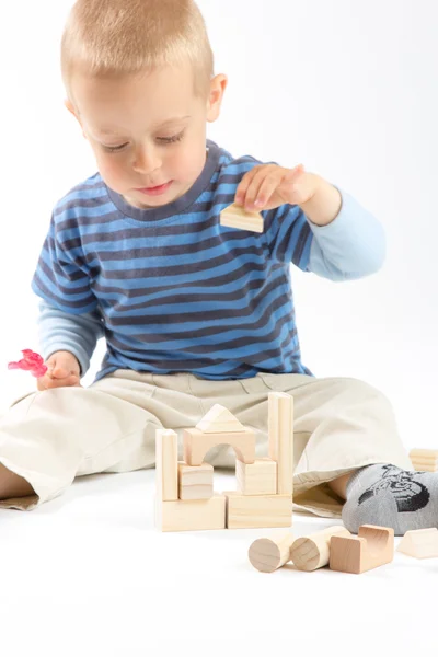Pequeño chico lindo jugando con bloques de construcción. Aislado sobre blanco . — Foto de Stock