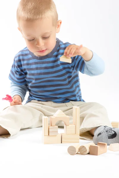 Weinig schattige jongen spelen met bouwstenen. geïsoleerd op wit. — Stockfoto