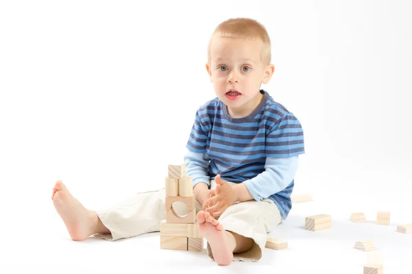 Menino bonito brincando com blocos de construção. Isolado em branco . — Fotografia de Stock