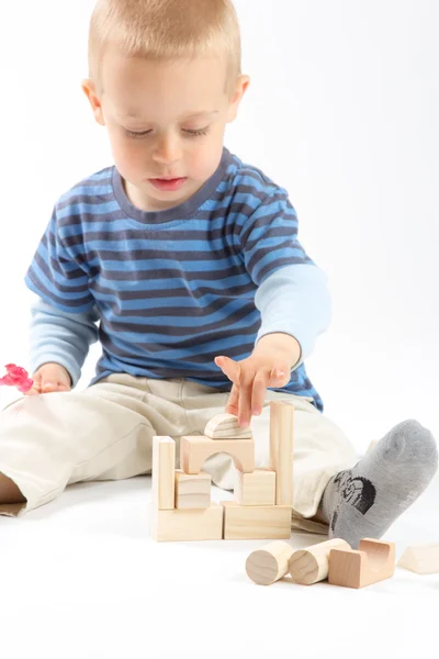 Маленький милый мальчик играет со строительными блоками. Изолированные на белом . — стоковое фото