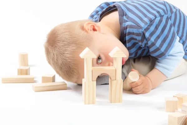 Little cute boy playing with building blocks. Isolated on white. Stock Image
