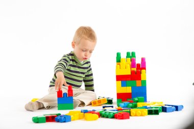 yapı taşları ile oynarken sevimli çocuk. beyaz izole.