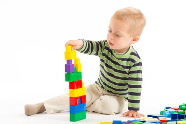 yapı taşları ile oynarken sevimli çocuk. beyaz izole.