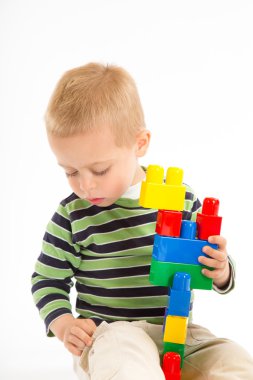yapı taşları ile oynarken sevimli çocuk. beyaz izole.
