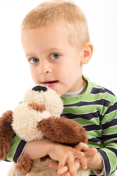 Little boy with his plush puppy. Isolated on white.