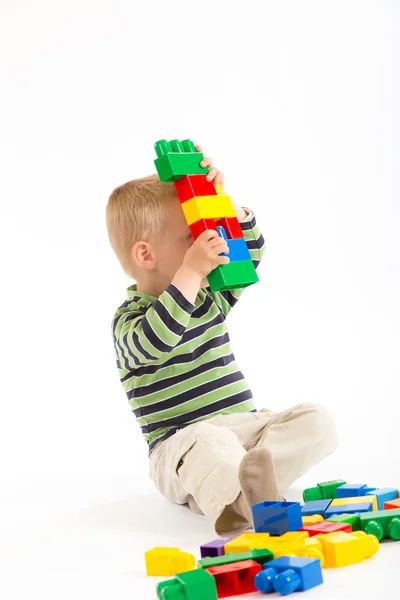 Weinig schattige jongen spelen met bouwstenen. geïsoleerd op wit. — Stockfoto