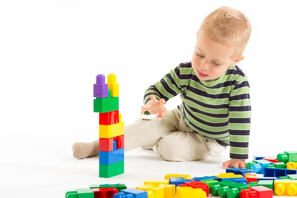 Menino bonito brincando com blocos de construção. Isolado em branco . — Fotografia de Stock