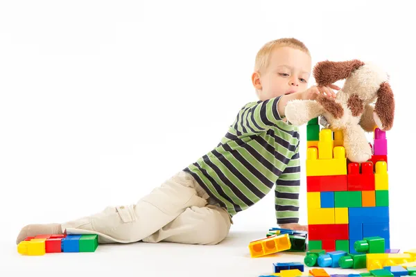 Liten söt pojke leker med byggstenar. isolerad på vit. — Stockfoto