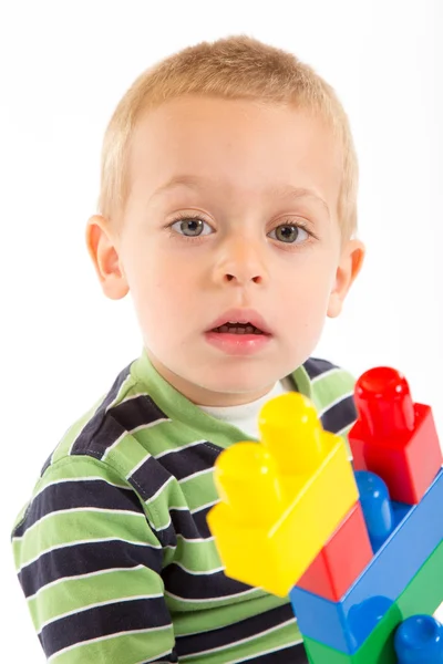 Piccolo ragazzo carino che gioca con i mattoni. Isolato su bianco . — Foto Stock