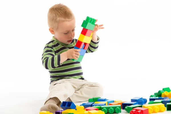 Menino bonito brincando com blocos de construção. Isolado em branco . — Fotografia de Stock