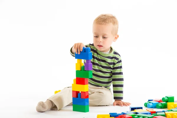 Little cute boy playing with building blocks. Isolated on white. — Stock Photo, Image