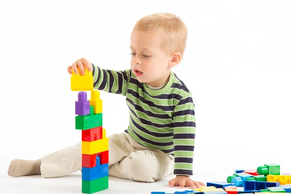 Liten söt pojke leker med byggstenar. isolerad på vit. — Stockfoto